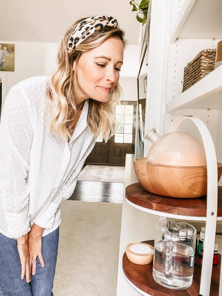 woman smelling essential oils from a diffuser
