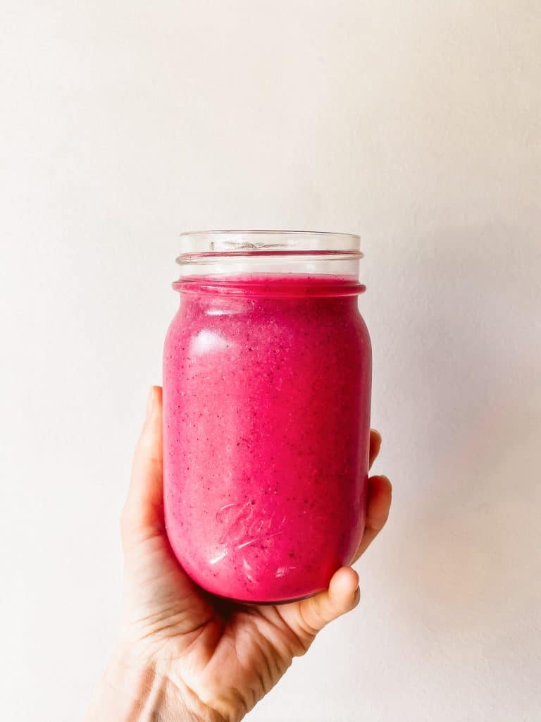 bright pink smoothie in a mason jar